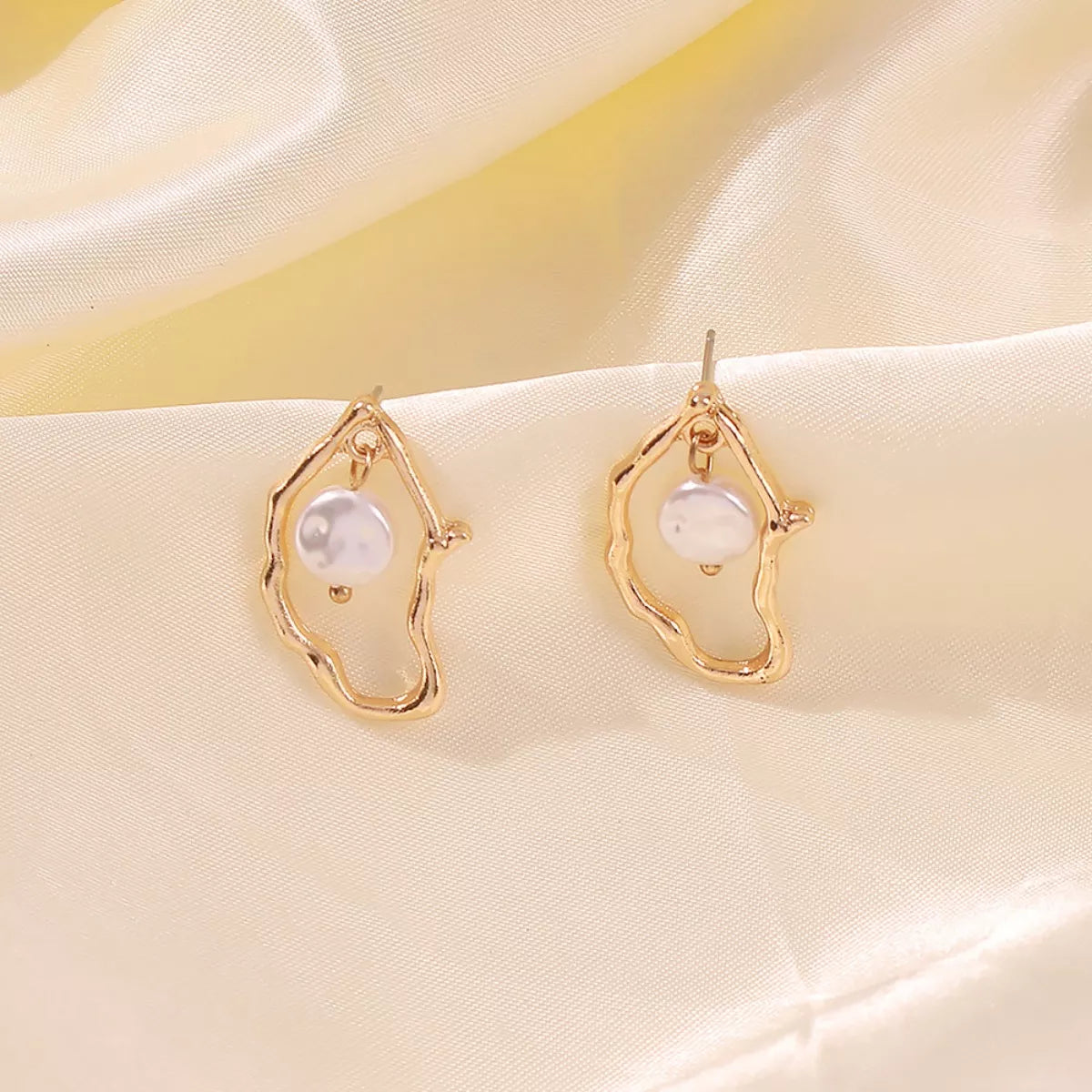 18K gold-plated pearl earrings featuring elegant, round pearls with a shiny gold finish, perfect for sophisticated style.