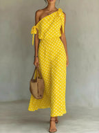 Plus size full-length polka dot one-shoulder maxi dress by Trendsi, featuring a flowing silhouette and stylish design.
