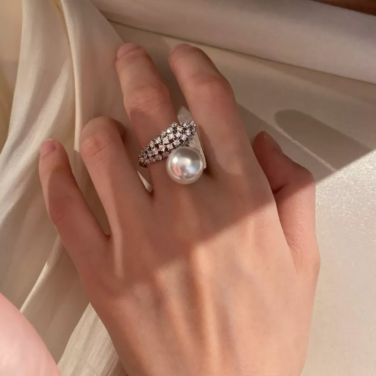Sterling silver pearl bypass ring featuring a sleek design and a smooth pearl accent, crafted by Shopimist.