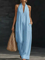 Halter neck wide-leg jumpsuit by Trendsi featuring a stylish design, fitted bodice, and flowing wide-leg pants in a sleek fabric.