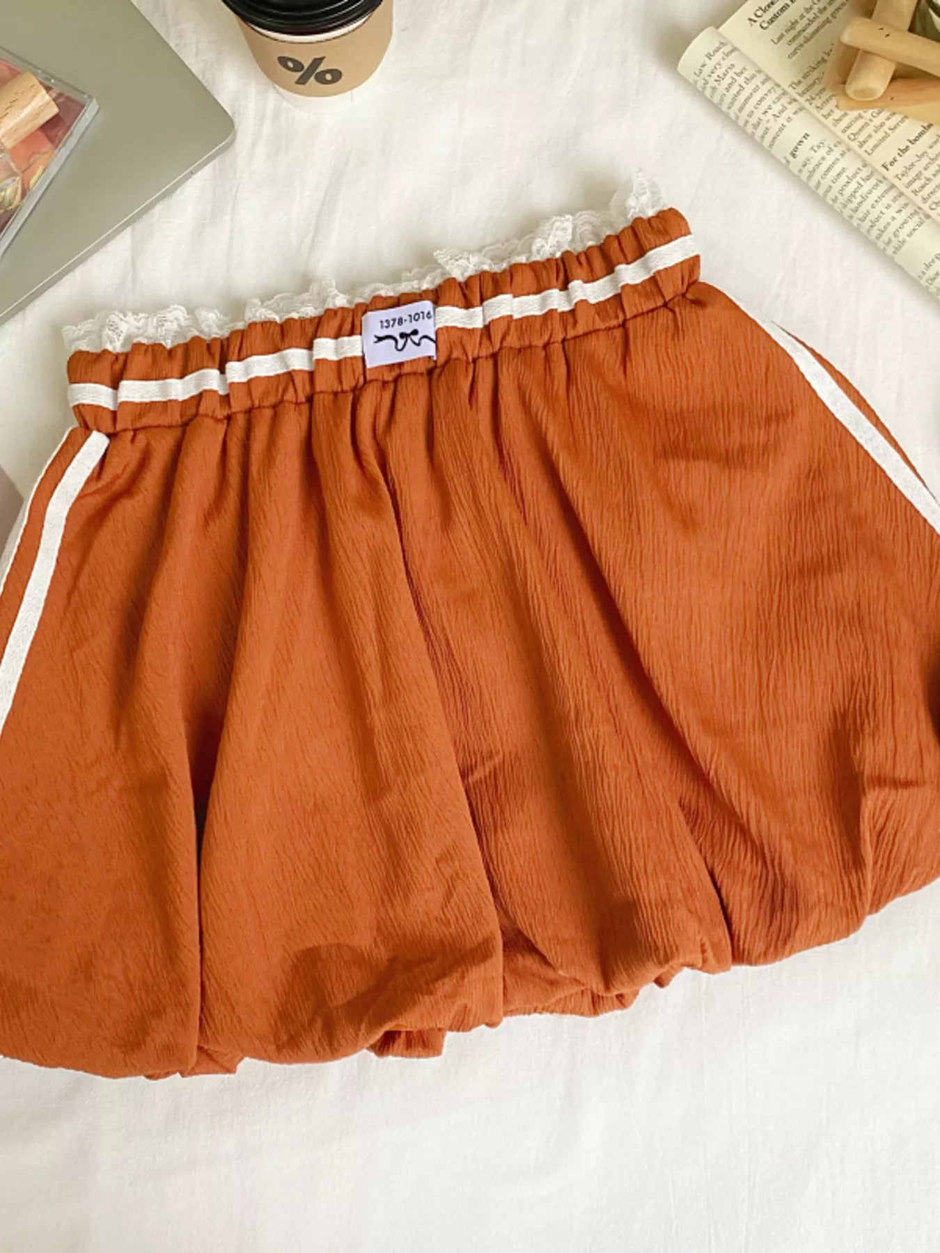 Lace trim elastic waist mini skirt by Trendsi showcasing a stylish fitted design with delicate lace details.