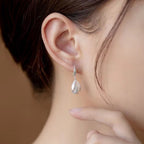 Sterling silver drop earrings with a sleek design, featuring polished silver teardrop shapes for elegant style.