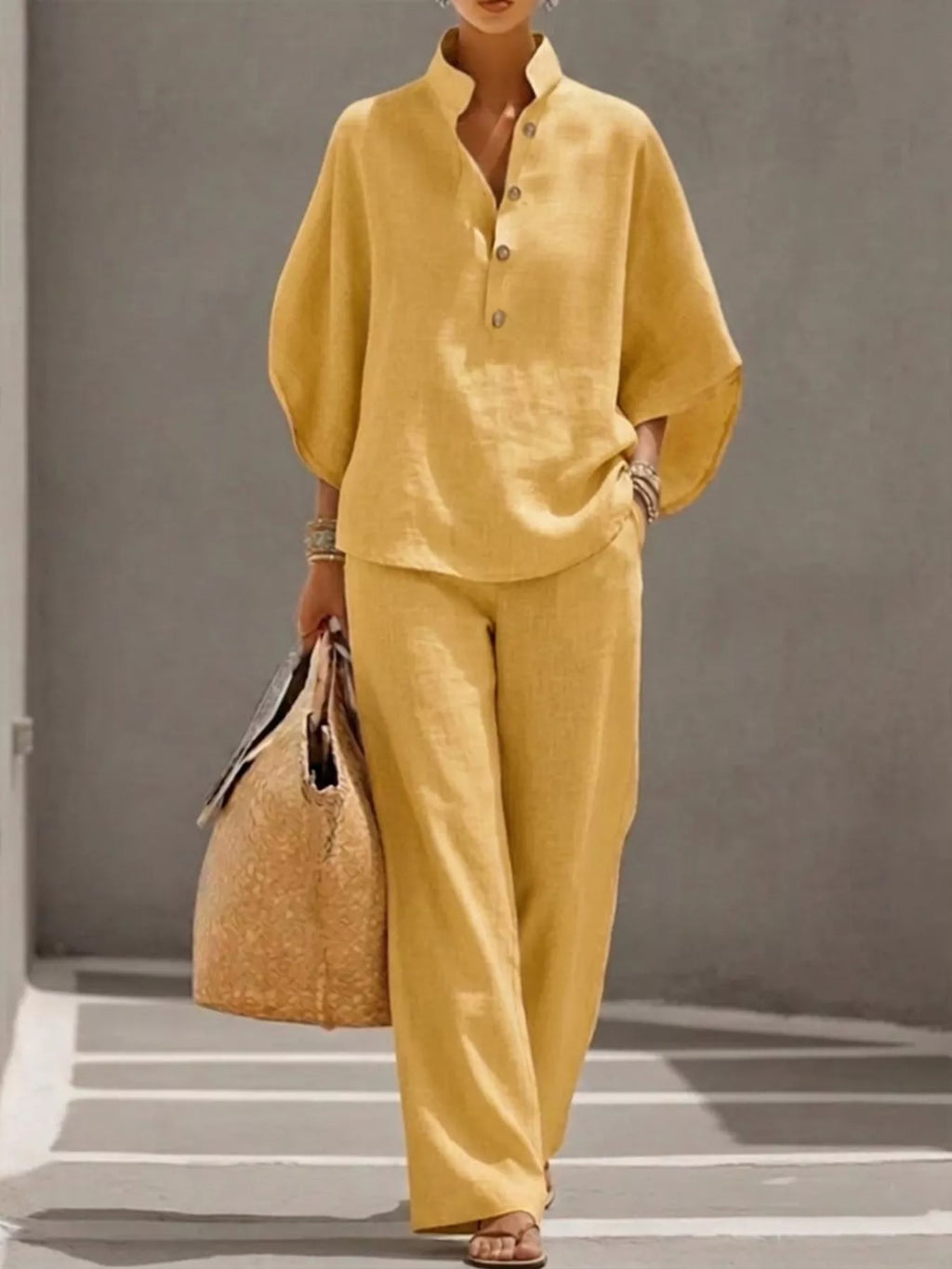 Plus size women's two-piece dress set with button detail, 3/4 sleeves top and matching pants by Trendsi.