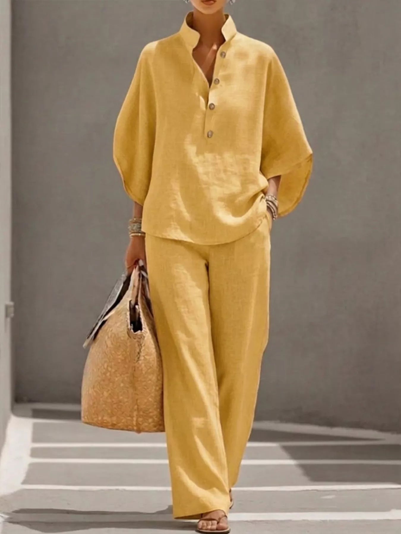 Plus size women's two-piece dress set with button detail, 3/4 sleeves top and matching pants by Trendsi.