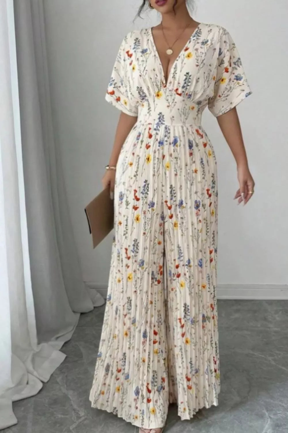Floral print wide-leg pleated jumpsuit by Trendsi, featuring a stylish design with flowing fabric and adjustable straps.