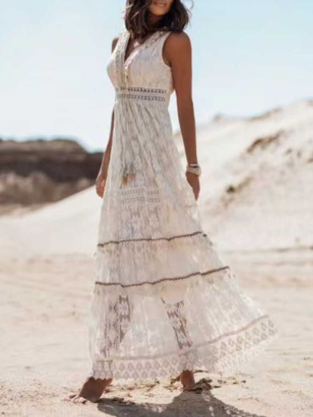 Ethereal V-neck lace sleeveless maxi dress with tassel accents, flowing design, lightweight fabric, perfect for elegant occasions.