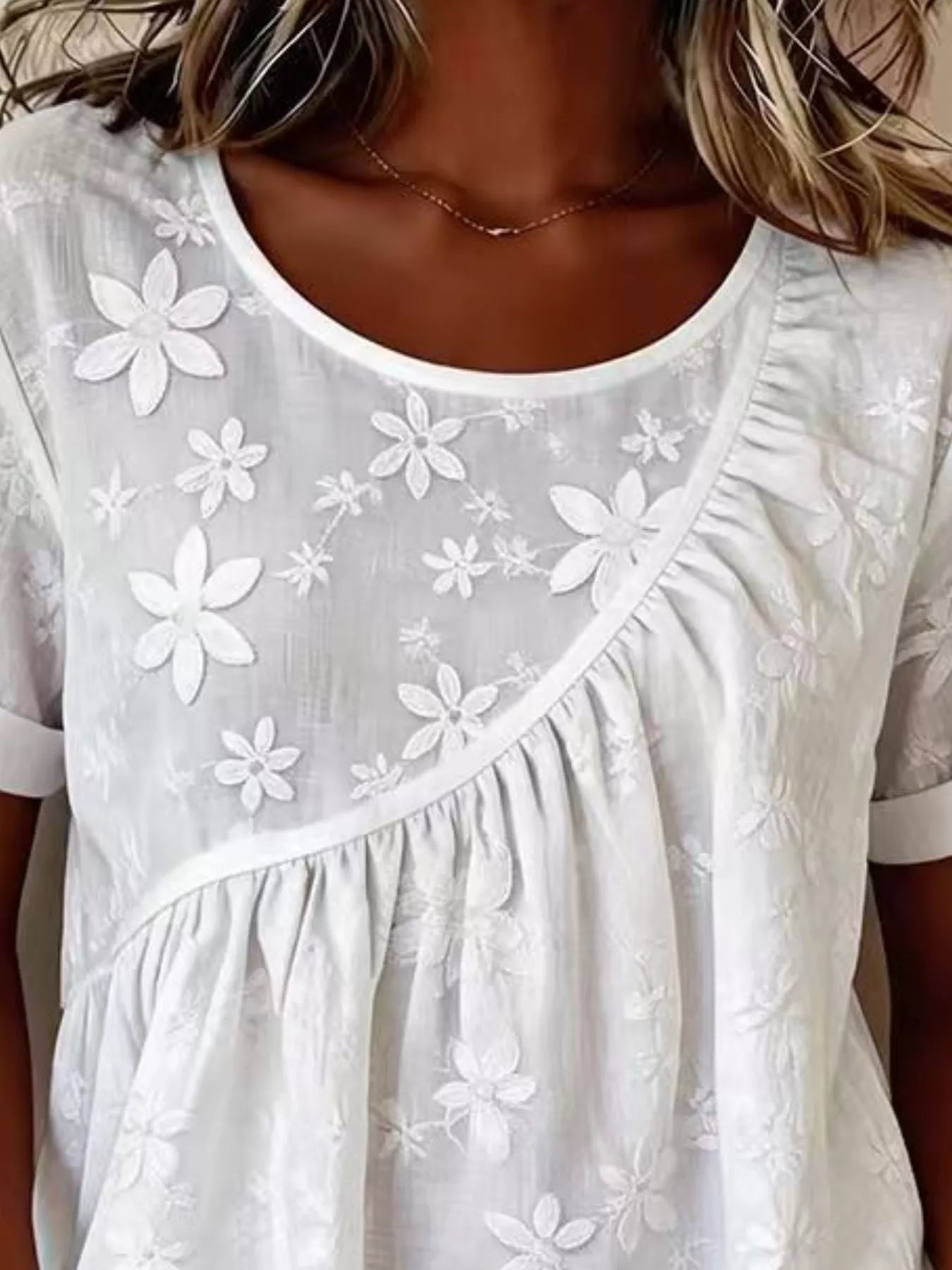 Plus size floral embroidered round neck short sleeve top by Trendsi, featuring colorful floral embroidery on a comfortable fabric.
