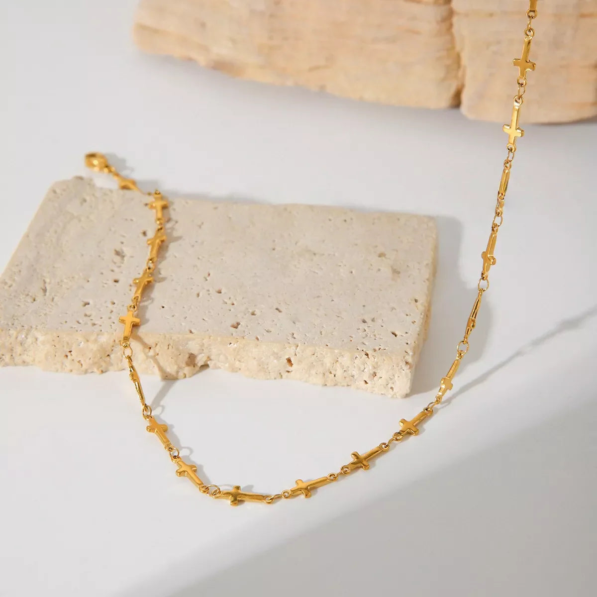 18K gold-plated cross necklace with delicate chain, showcasing a stylish religious pendant on a neutral background.