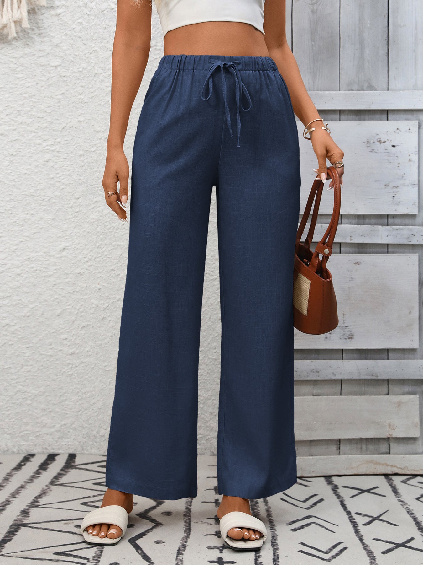 Women's high-waisted wide-leg drawstring pants in soft breathable viscose, shown in a relaxed fit with adjustable waist.