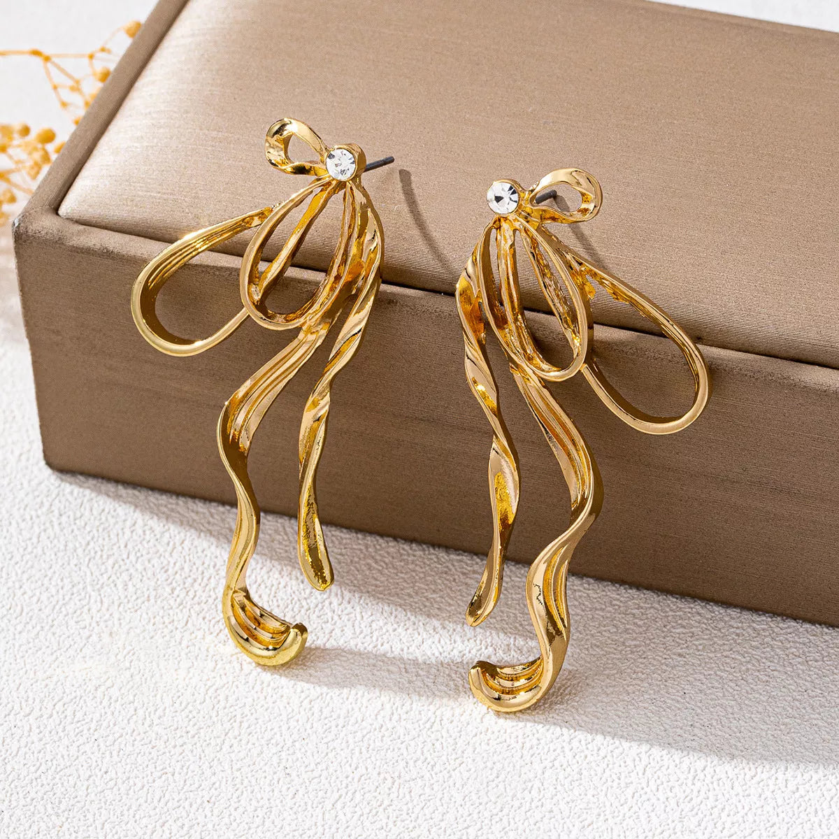 18K gold-plated bow earrings with delicate design, featuring shiny gold finish, perfect for elegant jewelry accessories.