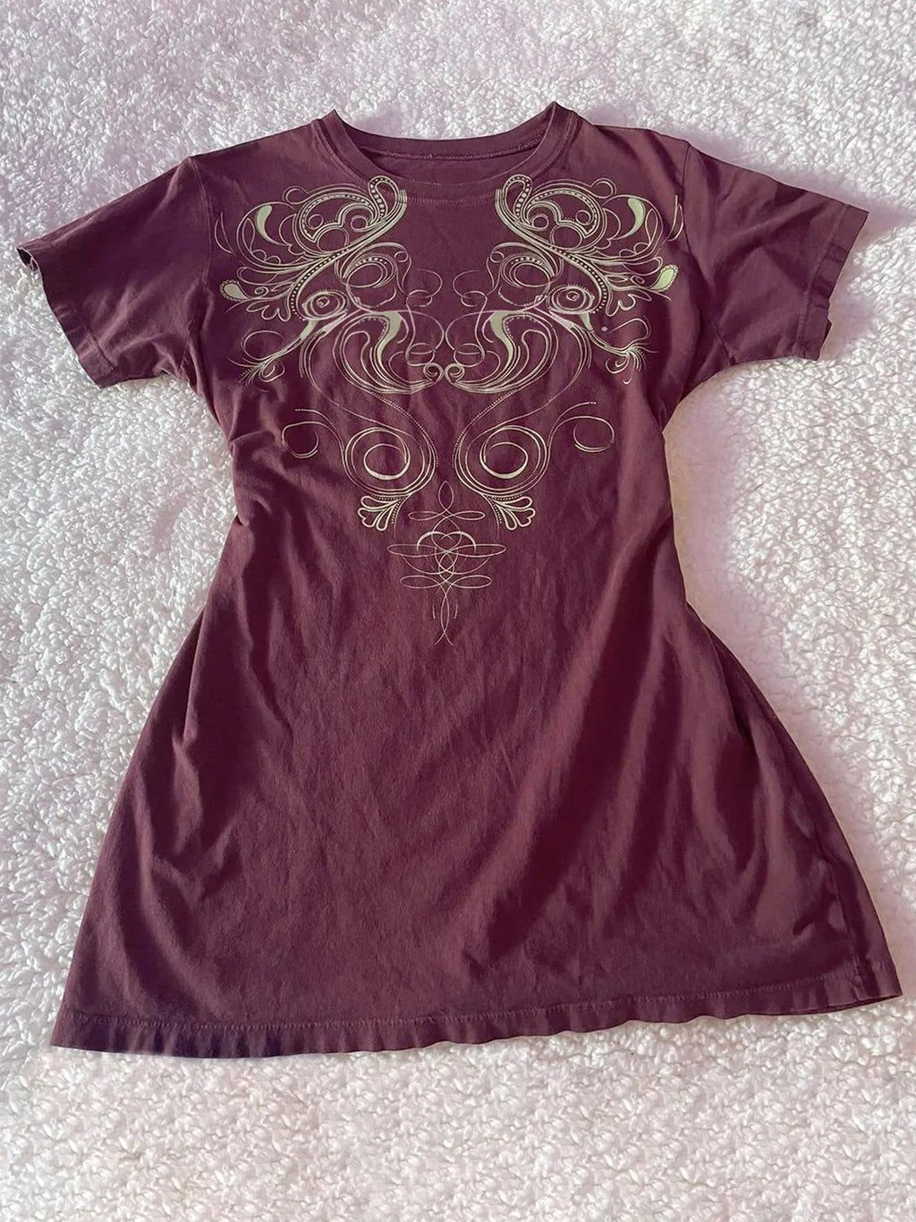 Graphic round neck short sleeve T-shirt from Trendsi, casual tops with a stylish design, shown on a hanger.