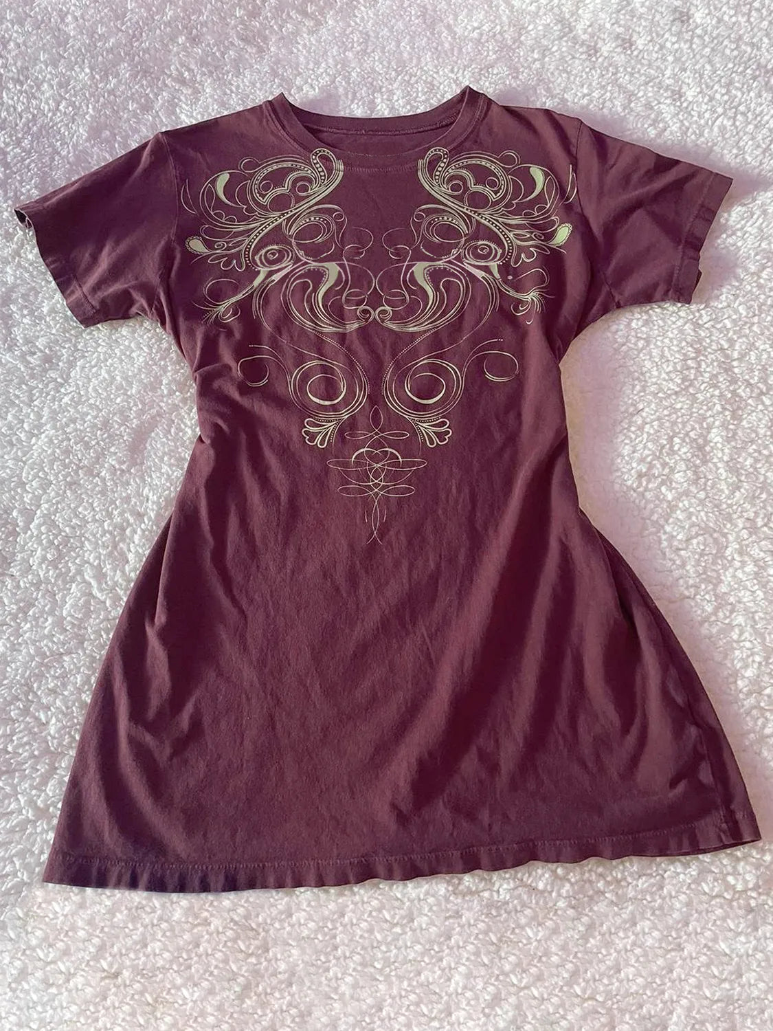 Graphic round neck short sleeve T-shirt from Trendsi, casual tops with a stylish design, shown on a hanger.