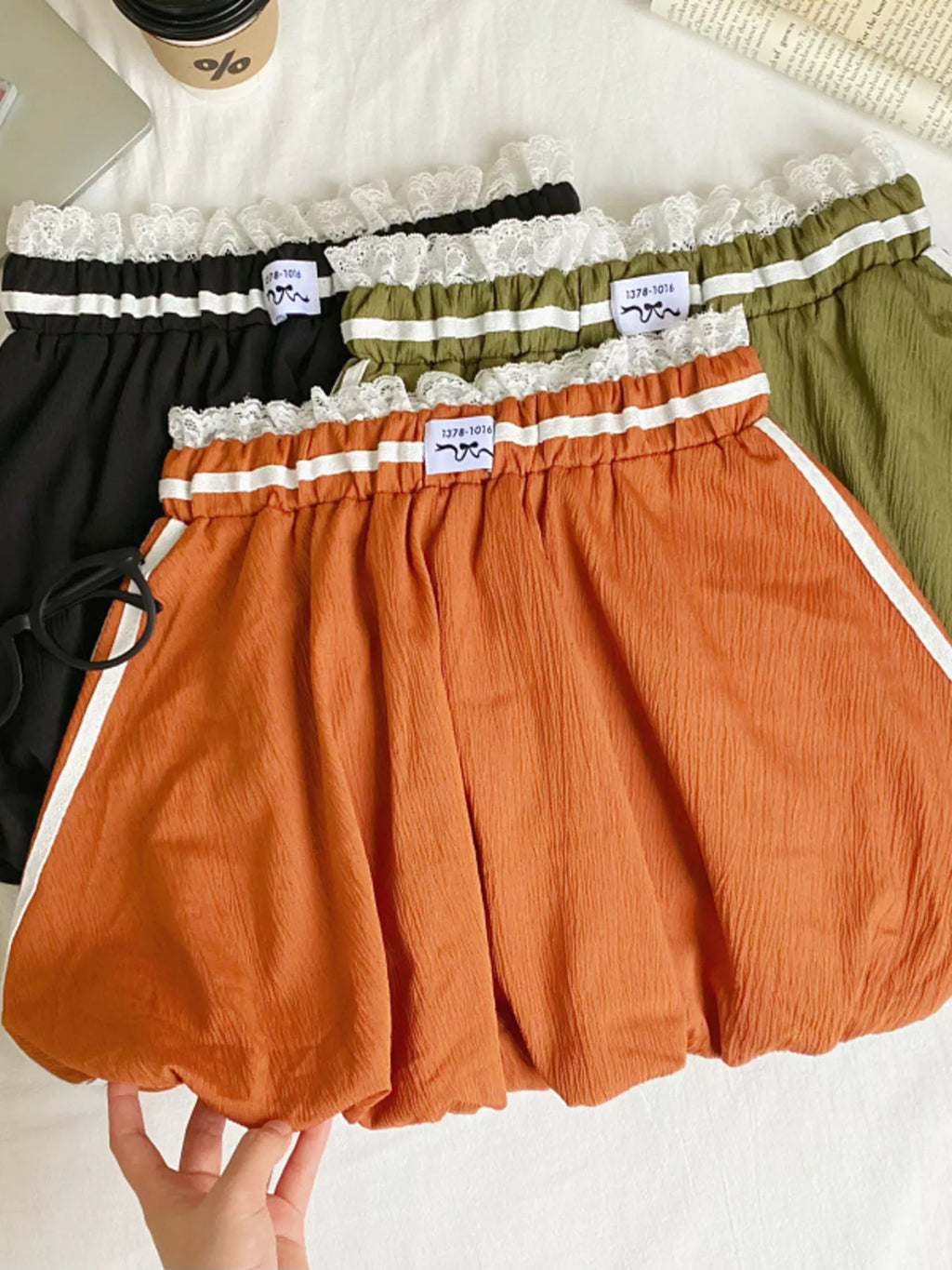 Lace trim elastic waist mini skirt from Trendsi featuring a stylish design and comfortable fit, shown in a flat lay view.