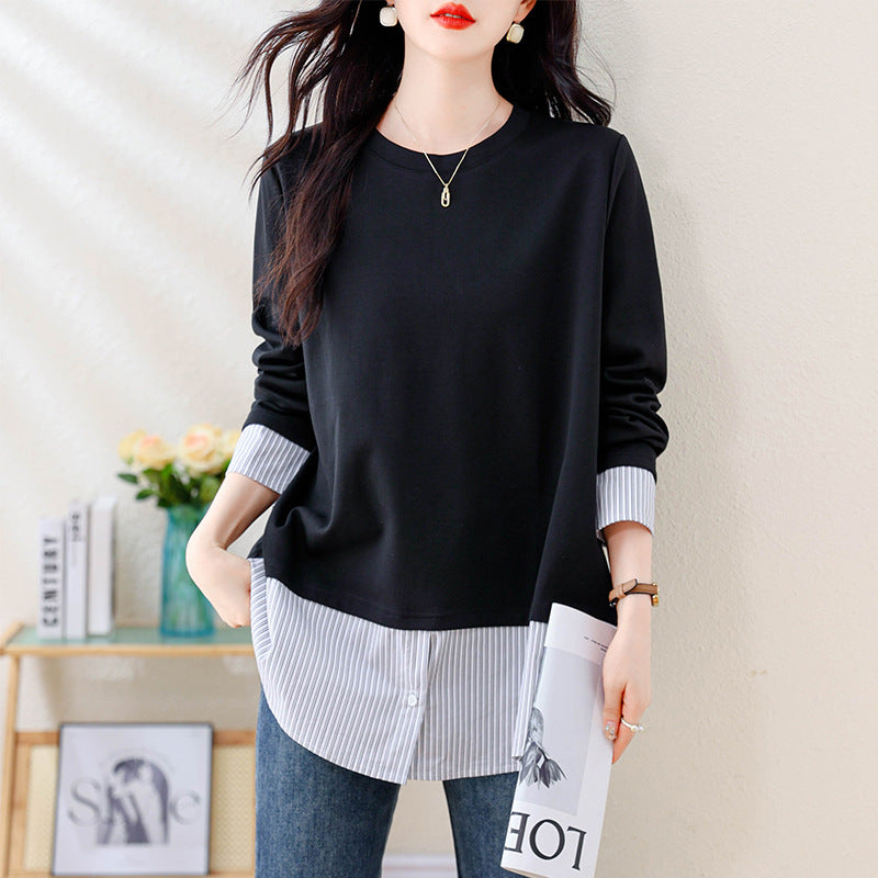 Black knit crewneck sweater with layered blue-and-white striped button-down cuffs and curved hem.