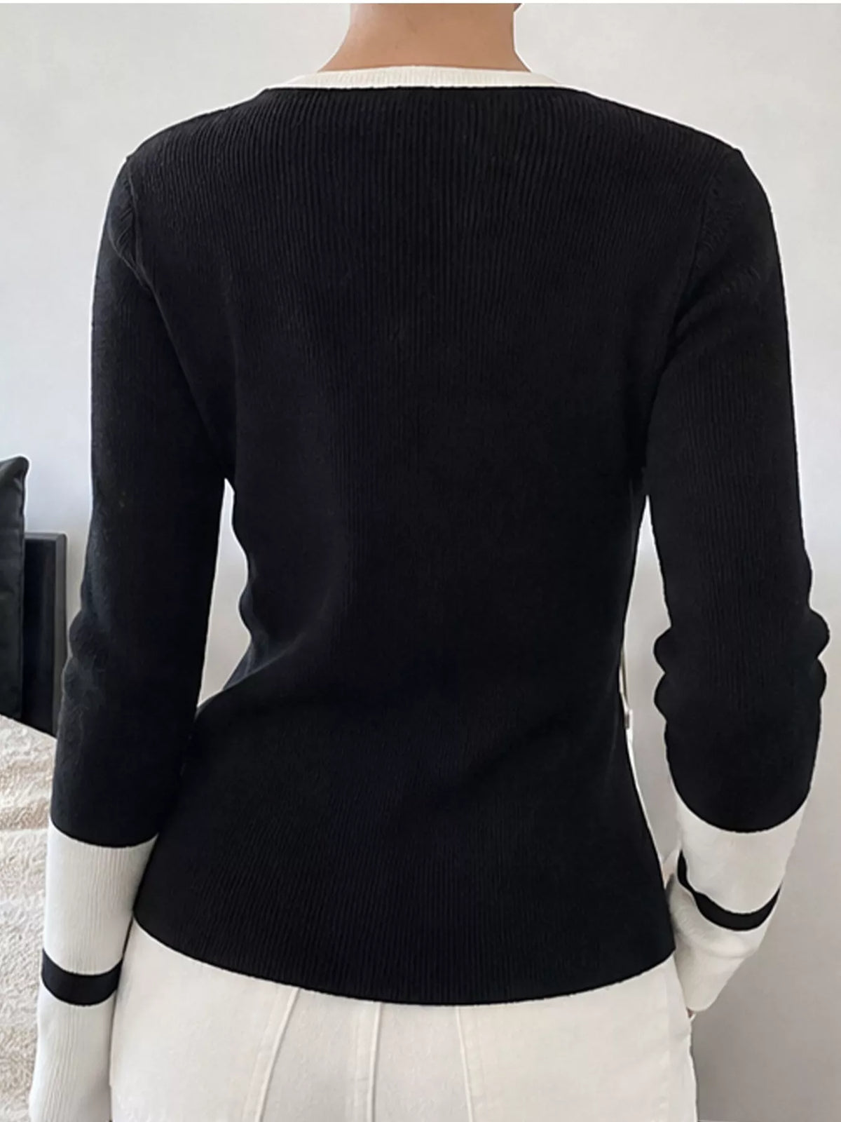 Black side slit sweater with contrasting trim from Trendsi, featuring a relaxed fit and stylish design.