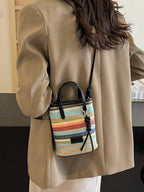 Striped woven mini crossbody bag with adjustable strap and zipper closure, featuring a colorful, trendy design.
