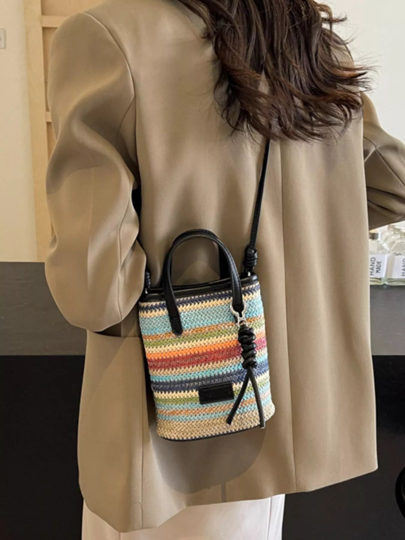 Striped woven mini crossbody bag with adjustable strap and zipper closure, featuring a colorful, trendy design.