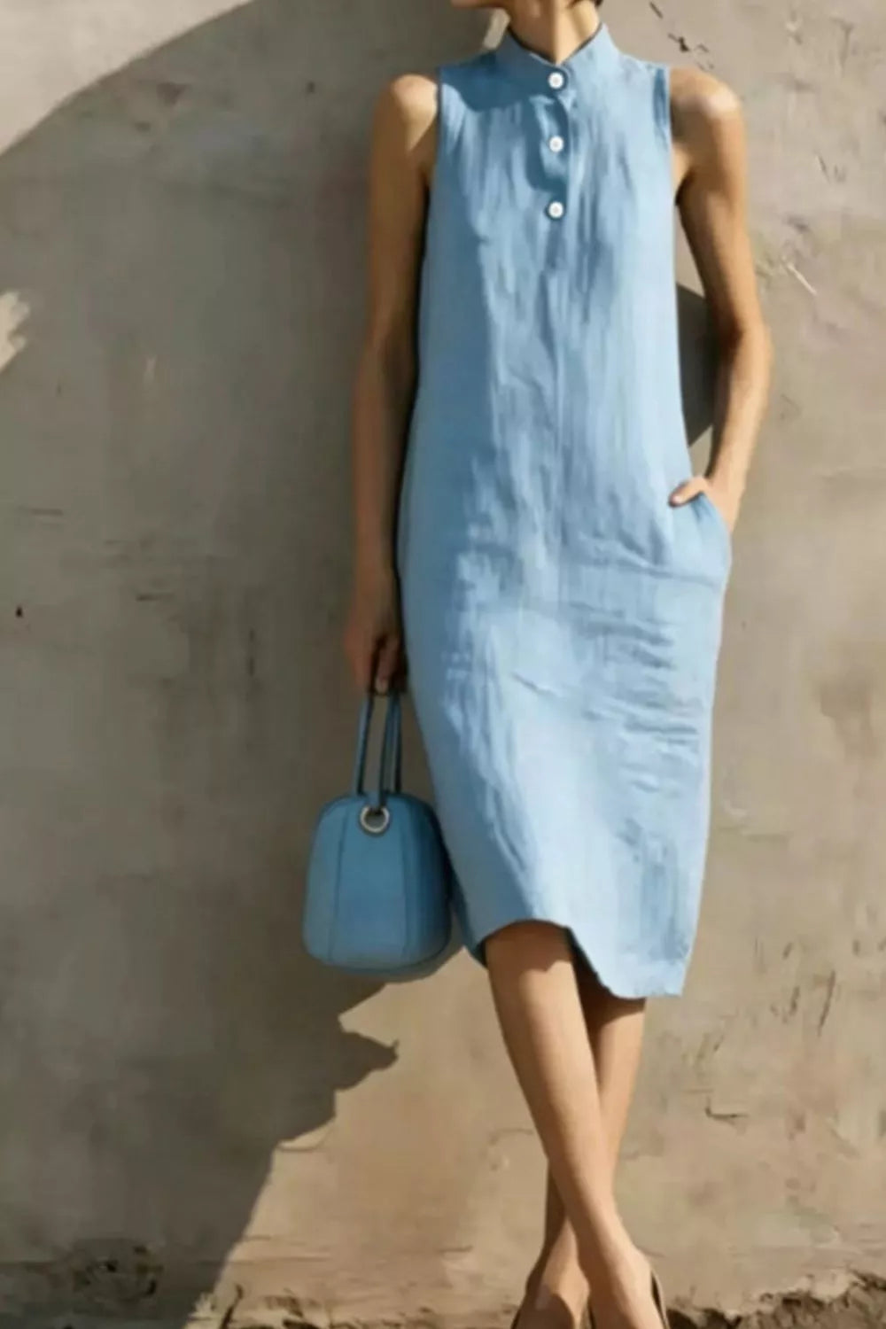 Casual sleeveless midi dress with button details by Trendsi, featuring a relaxed fit and stylish design perfect for everyday wear.