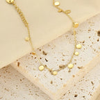 18K gold-plated charm bracelet with various decorative charms, showcasing shiny gold finish and intricate detailing.