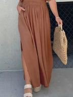 Plus size full length maxi dress with slit, V-neck, smocked waist, from Trendsi, featuring a flowing fabric and elegant design.