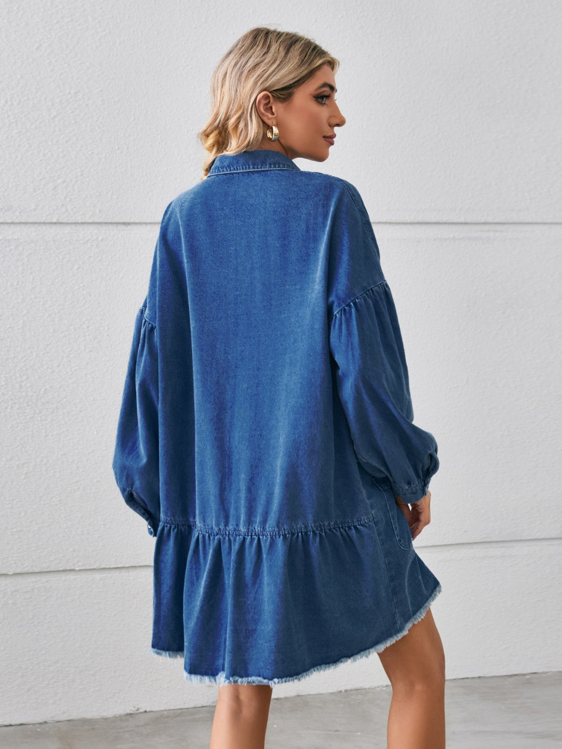 VYSN button-up denim dress with pocketed design, raw hem, and long sleeves, displayed on a hanger.