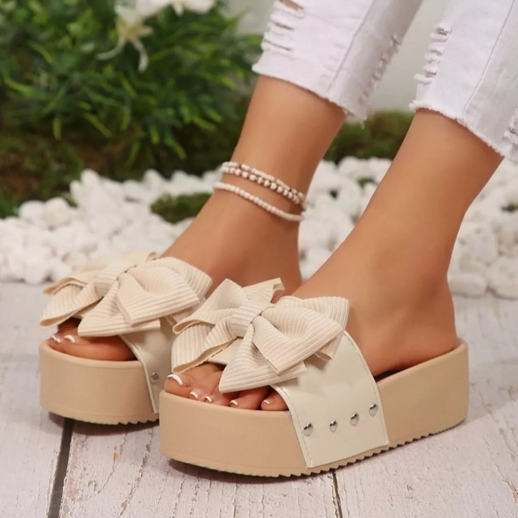Women's platform sandals with bow decor by Trendsi, featuring a comfortable flat sole and stylish design for casual wear.