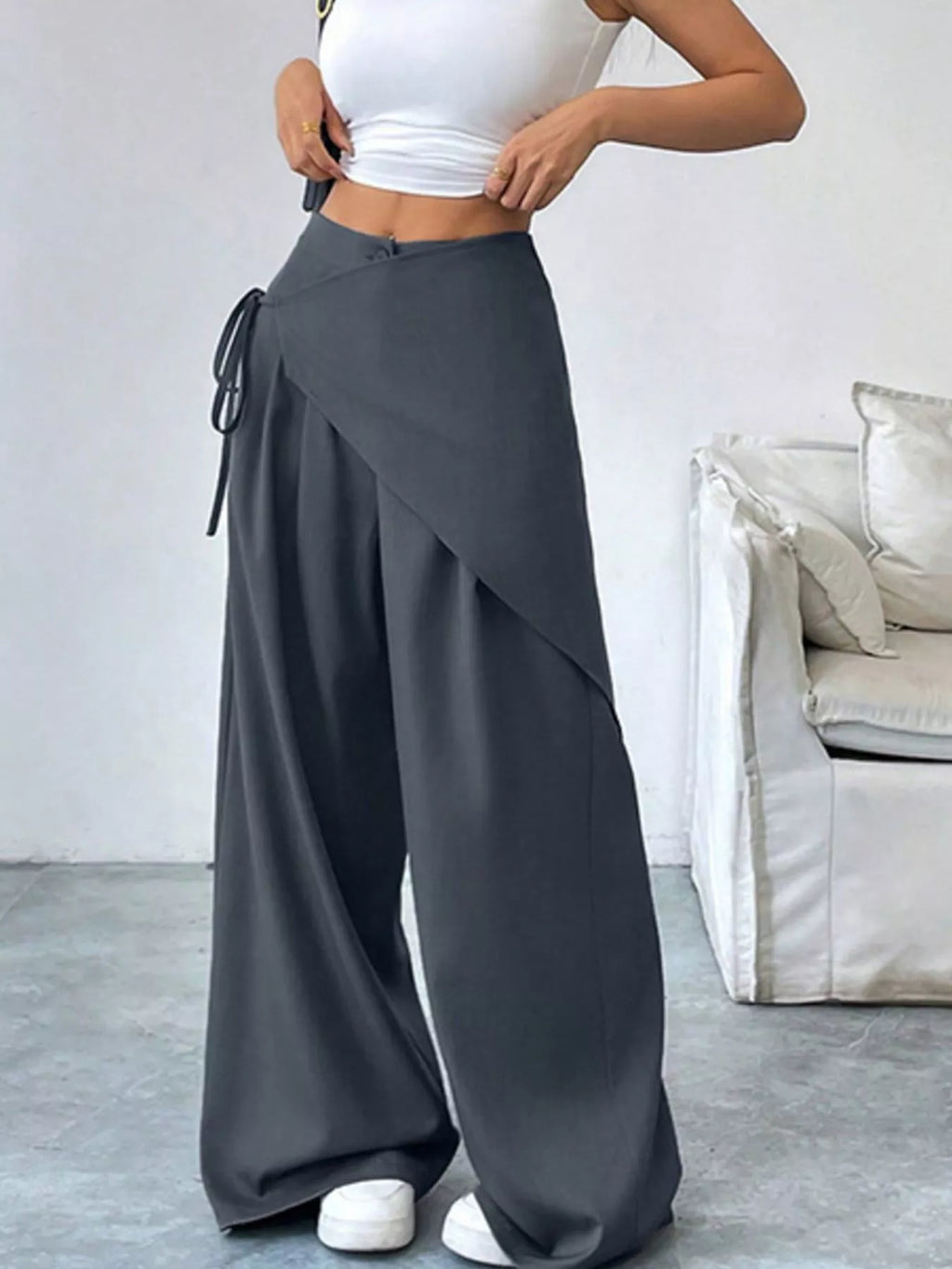 Asymmetrical wrap wide-leg pants by Plush Fashion Hub featuring flowing fabric and a stylish, modern design.