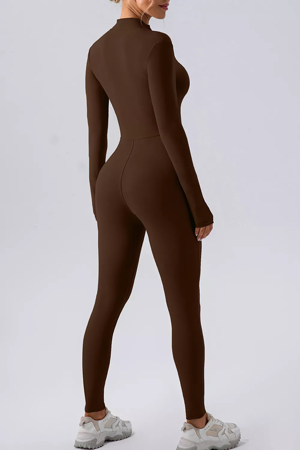 Black half zip mock neck active jumpsuit by Trendsi, featuring a fitted design and full-length legs for workout or casual wear.