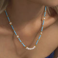 Turquoise pearl beaded necklace from Shopimist featuring a string of vibrant turquoise pearls on a delicate chain.