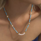 Turquoise pearl beaded necklace from Shopimist featuring a string of vibrant turquoise pearls on a delicate chain.