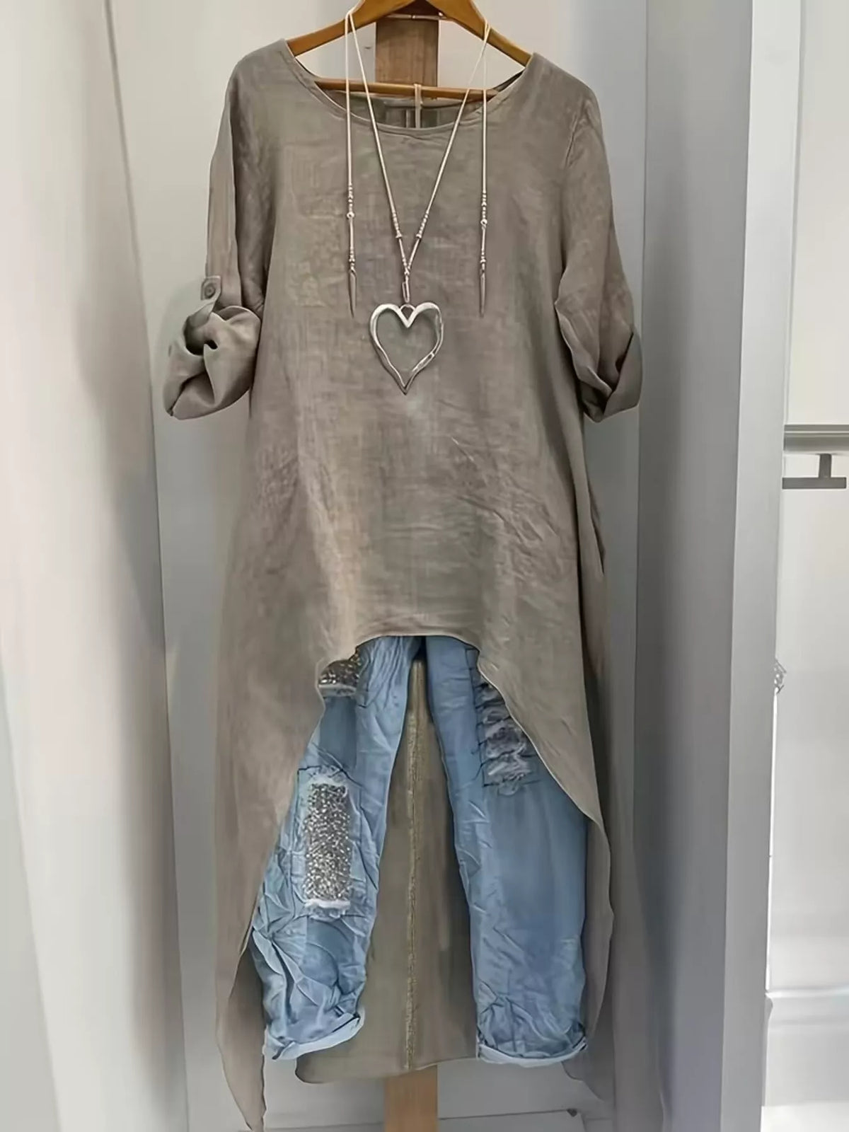 Trendsi high-low hem blouse with roll-up sleeves, lightweight fabric, and relaxed fit, shown on a model.
