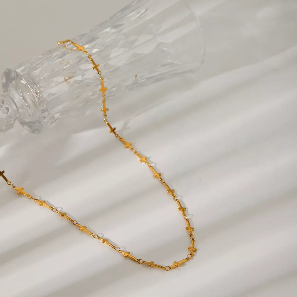 18K gold-plated cross necklace with delicate chain, showcasing a shiny, polished finish and classic religious pendant.