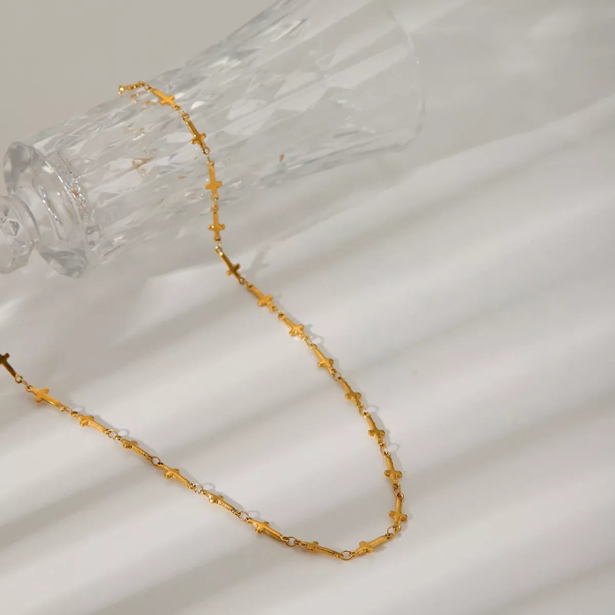 18K gold-plated cross necklace with delicate chain, showcasing a shiny, polished finish and classic religious pendant.