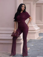 Ruched flare leg jumpsuit by Trendsi featuring a fitted bodice, flared pants, and ruched details, displayed on a model.