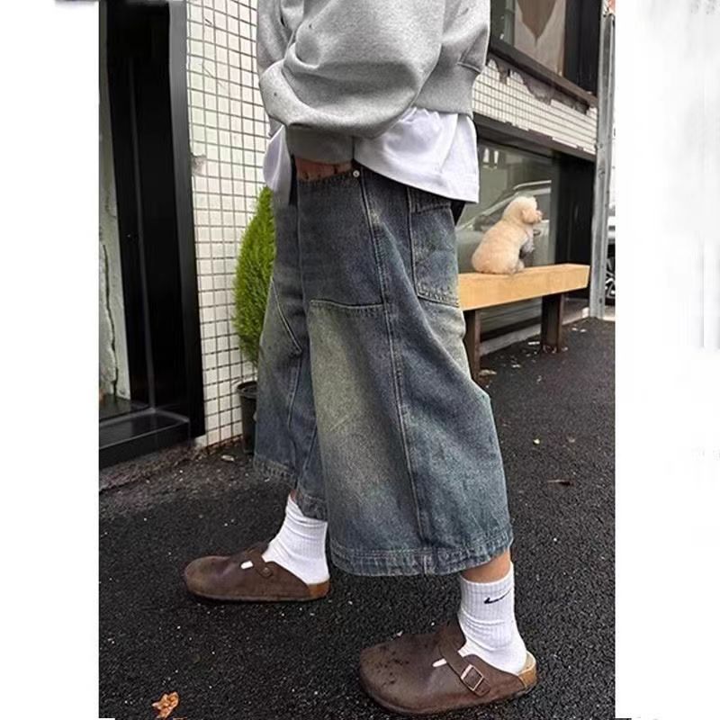 Vintage distressed wide-leg denim shorts by eprolo, featuring a relaxed fit and frayed hems, styled with rolled-up cuffs.
