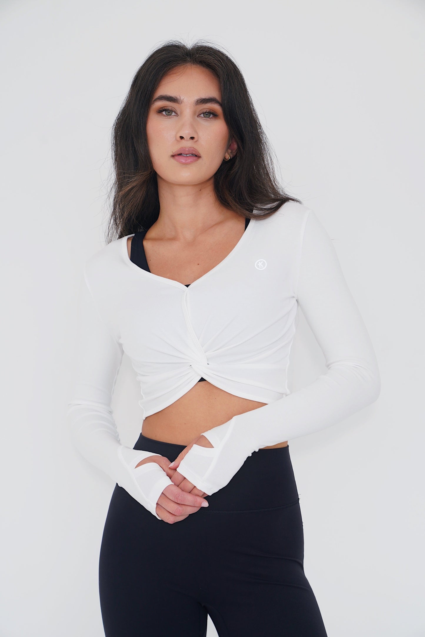 KIMITH BRAND buttery soft white long sleeve crop top bra with a fitted design, shown on a model.