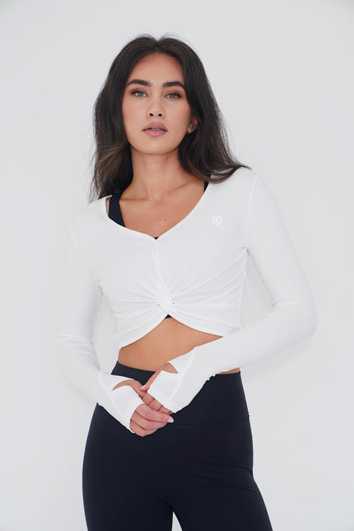 KIMITH BRAND buttery soft white long sleeve crop top bra with a fitted design, shown on a model.