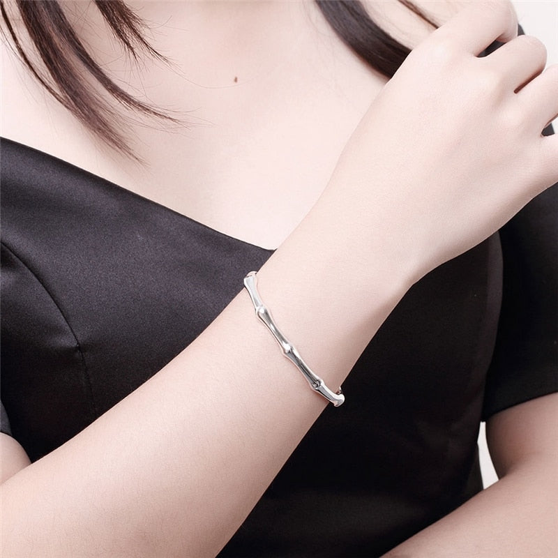 Silver bamboo-joint bracelet made of metal, styled with segmented nodes on a woman’s wrist.