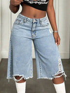 Distressed wide-leg denim shorts by Shopimist with frayed hem and vintage wash, shown on a model against a neutral background.