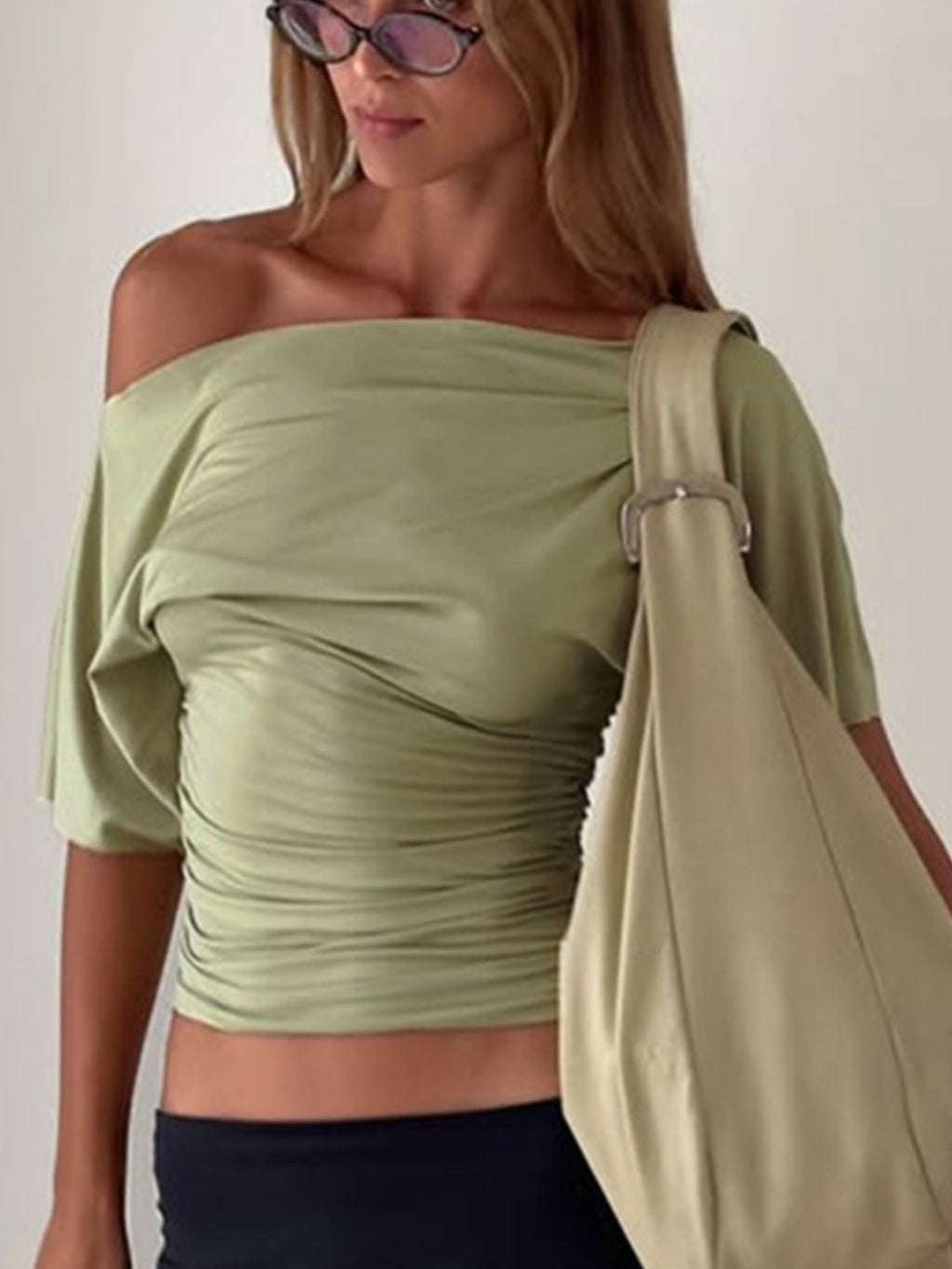 Women's one shoulder ruched short sleeve T-shirt by Trendsi, featuring a fitted stretch fabric and stylish design in a close-up image.