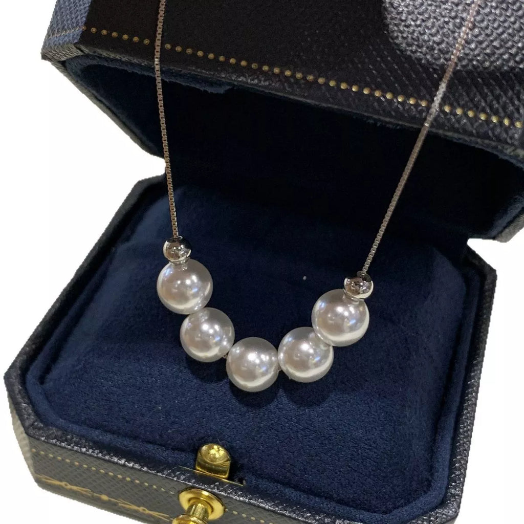 Adjustable pearl necklace with white pearls and silver clasp, stylish jewelry by Shopimist displayed on a neutral background.