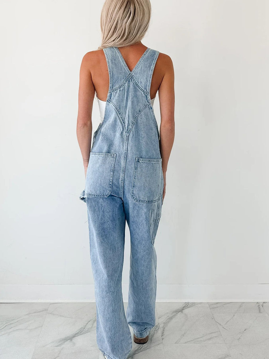 Women's relaxed fit wide strap denim jumpsuit by Trendsi, featuring casual style and comfortable relaxed fit.