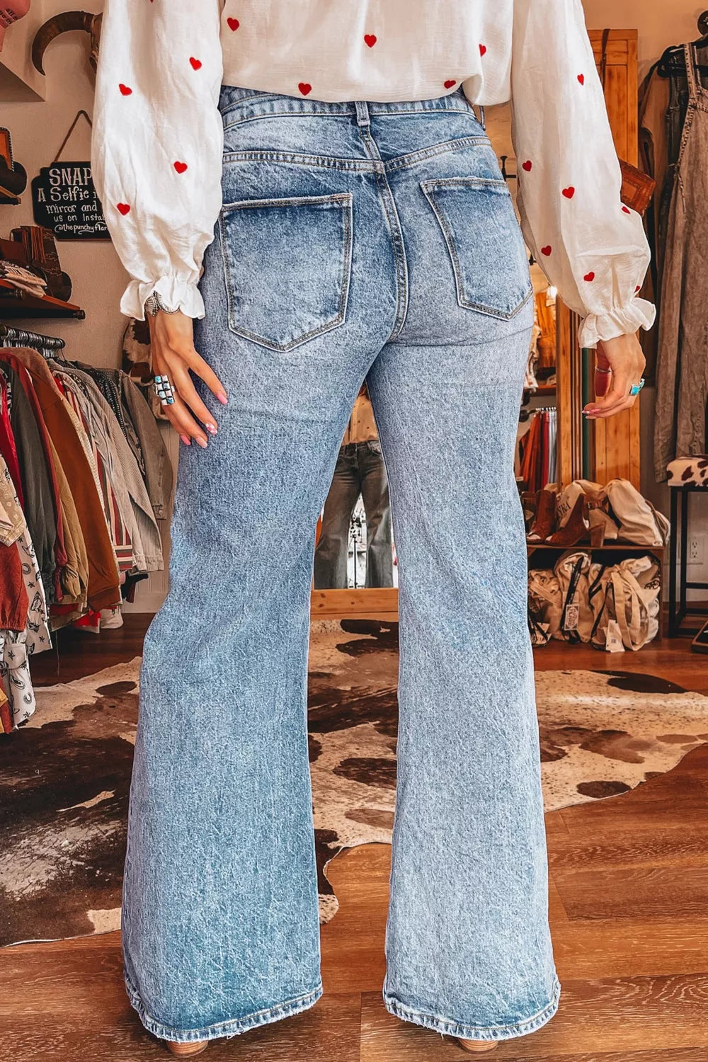 Acid wash flare jeans with pocket details from Plush Fashion Hub, showing the distressed denim fabric and stylish flare silhouette.