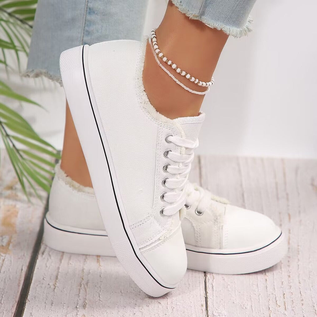Women's lightweight lace-up canvas sneakers with flat low-top design from Plush Fashion Hub, showing white casual footwear.