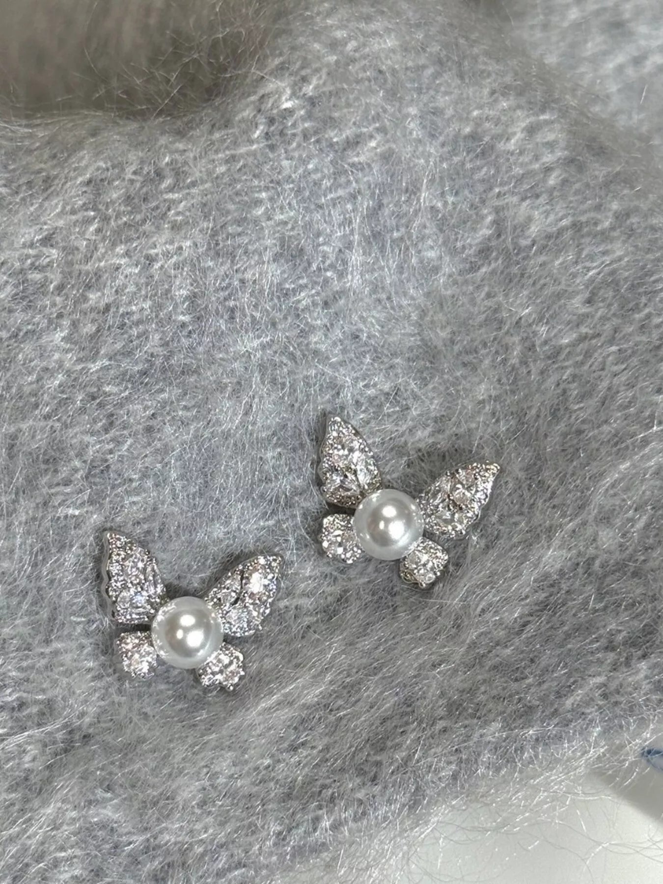 Butterfly-shaped pearl stud earrings by Shopimist featuring elegant white pearls and silver butterfly accents.