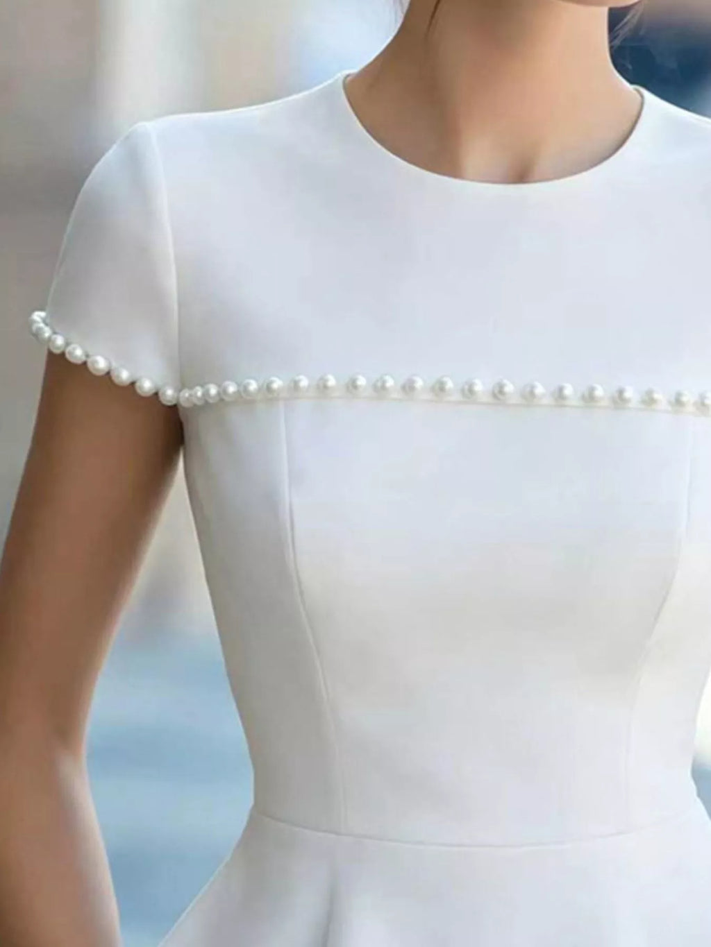 Pearl-embellished Shopimist peplum T-shirt with a fitted silhouette and stylish design, shown on a model.