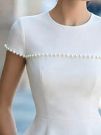 Pearl-embellished Shopimist peplum T-shirt with a fitted silhouette and stylish design, shown on a model.