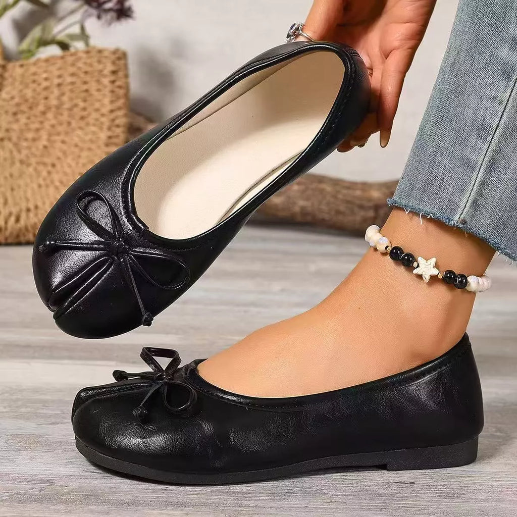 Black Bow Decor Split Toe Slip-On Shoes by Trendsi featuring stylish bow accents and comfortable slip-on design.