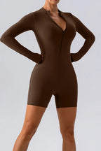 Trendsi half zip long sleeve active romper in black, made of stretchy athletic fabric, suitable for workout or casual wear.