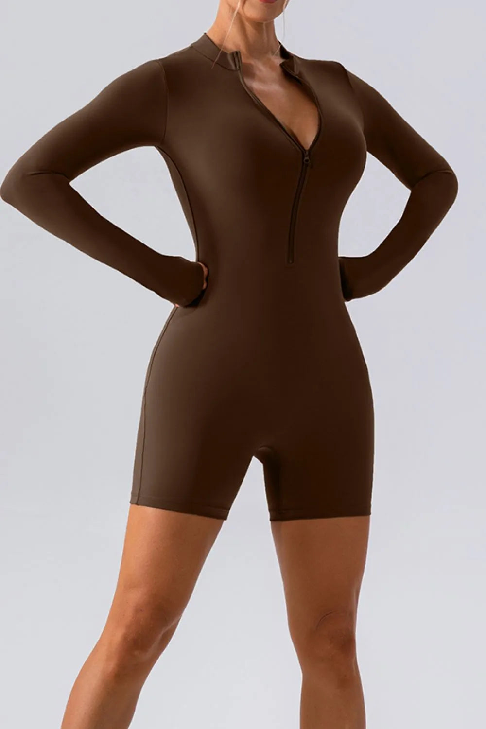 Trendsi half zip long sleeve active romper in black, made of stretchy athletic fabric, suitable for workout or casual wear.